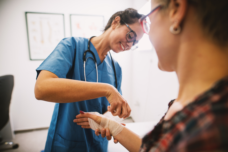 nurse bandaging a patient's hand